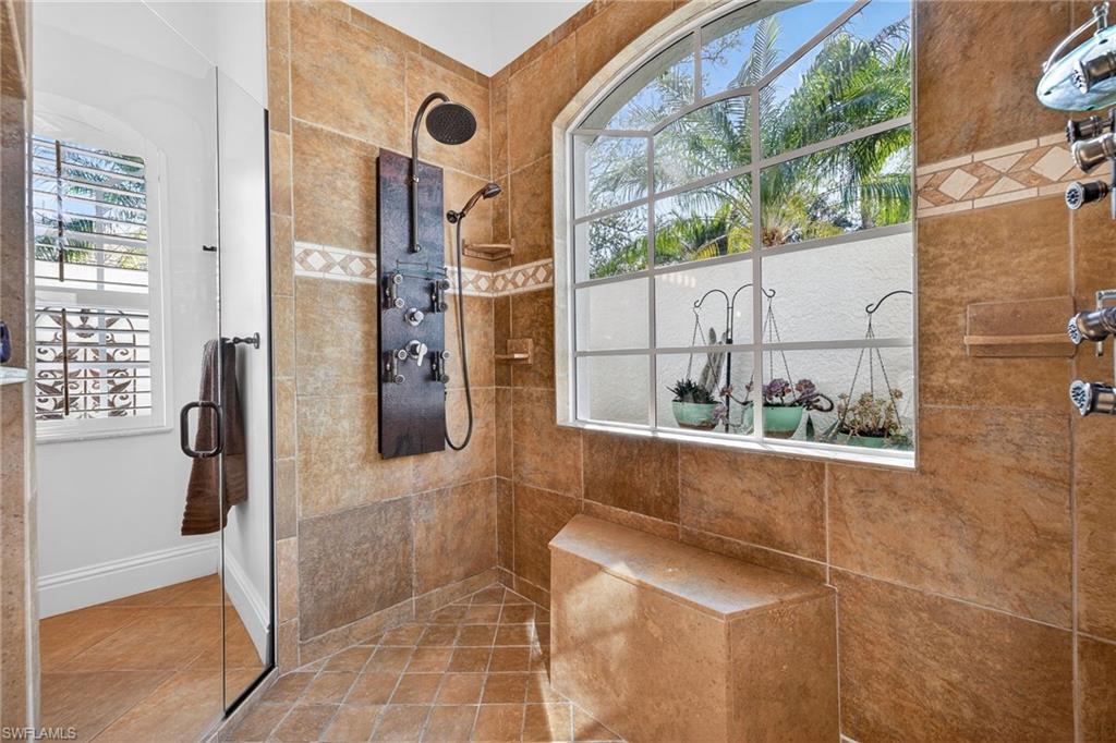 Bathroom with a tile shower and baseboards