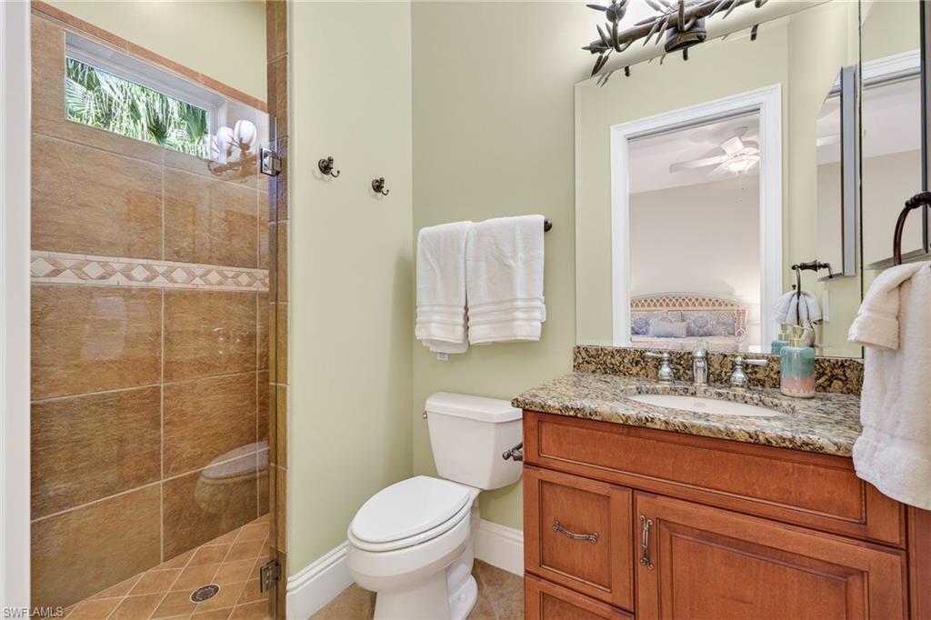 Full bath with a stall shower, vanity, ensuite bath, and ceiling fan