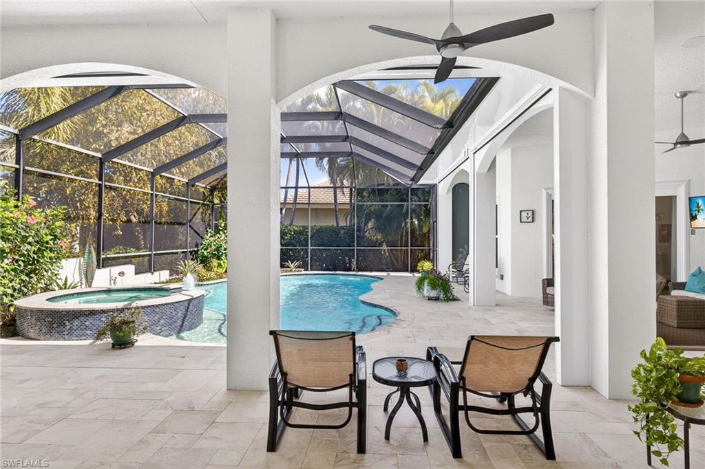 Combined pool / hot tub with a patio, glass enclosure, and a sunroom