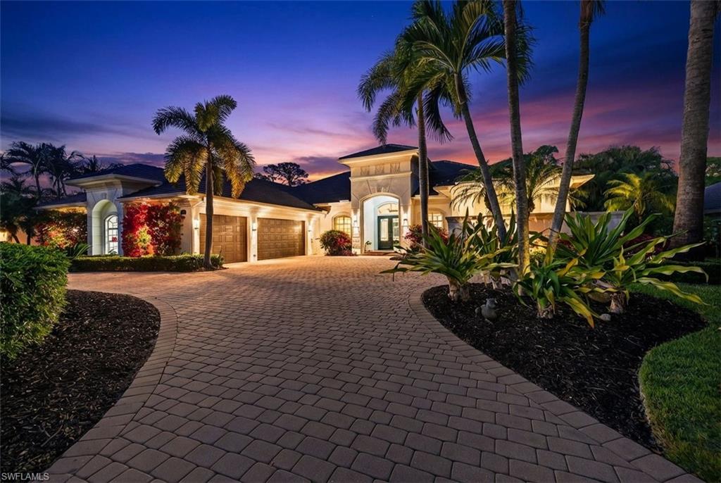Mediterranean / spanish house featuring curved driveway and a garage