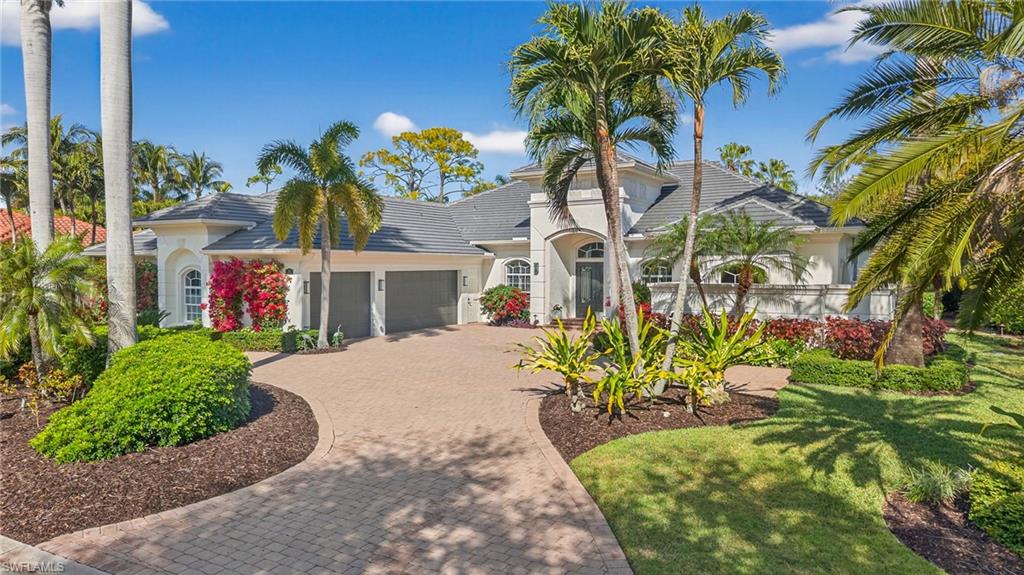 View of front of home with decorative driveway, stucco siding, an attached garage, and a tile roof