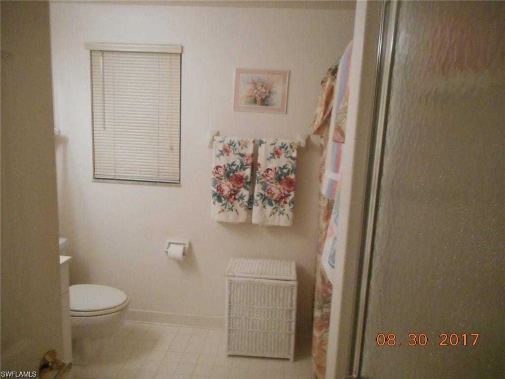 Bathroom featuring a shower with shower curtain and baseboards