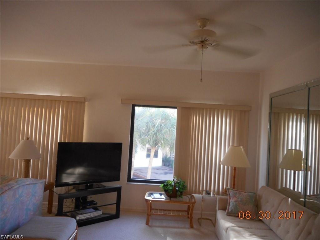 Living area featuring ceiling fan and carpet flooring