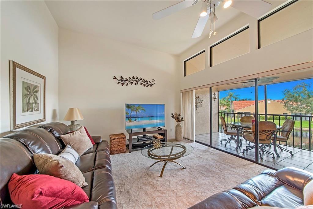 Living room with a ceiling fan and a high ceiling
