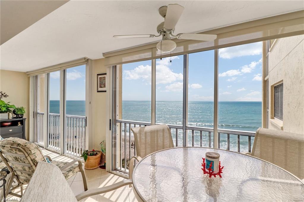 Sunroom / solarium featuring a water view, expansive windows, and tile patterned flooring