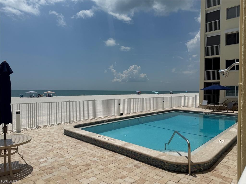 Community pool featuring a patio and a water view