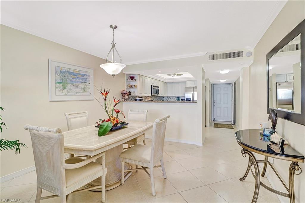 Dining space featuring ornamental molding and light tile patterned floors