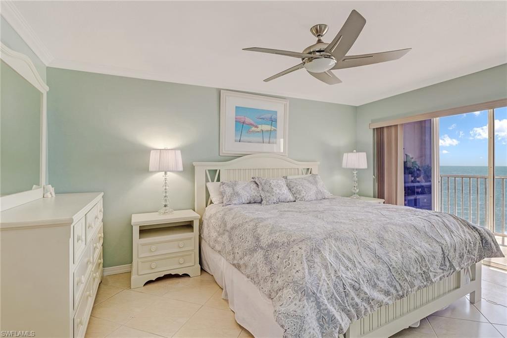 Bedroom featuring access to exterior, ceiling fan, a water view, and light tile patterned floors