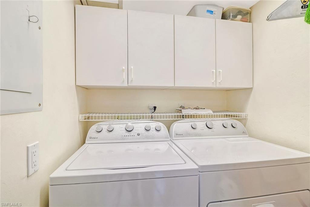 Laundry room featuring cabinet space, separate washer and dryer, and electric panel