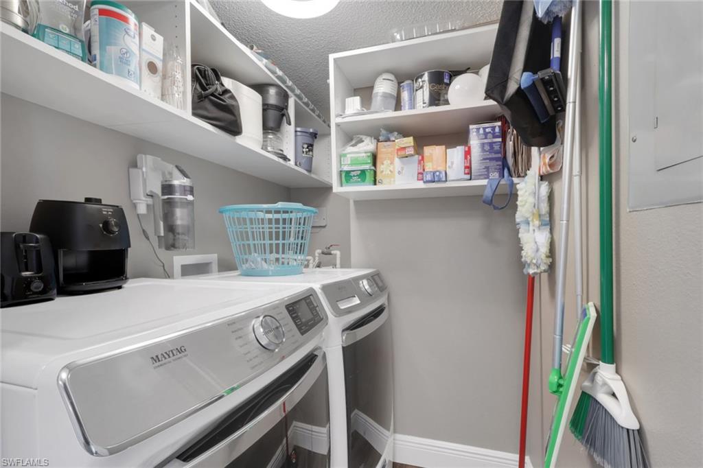Laundry room with washing machine and clothes dryer and electric panel