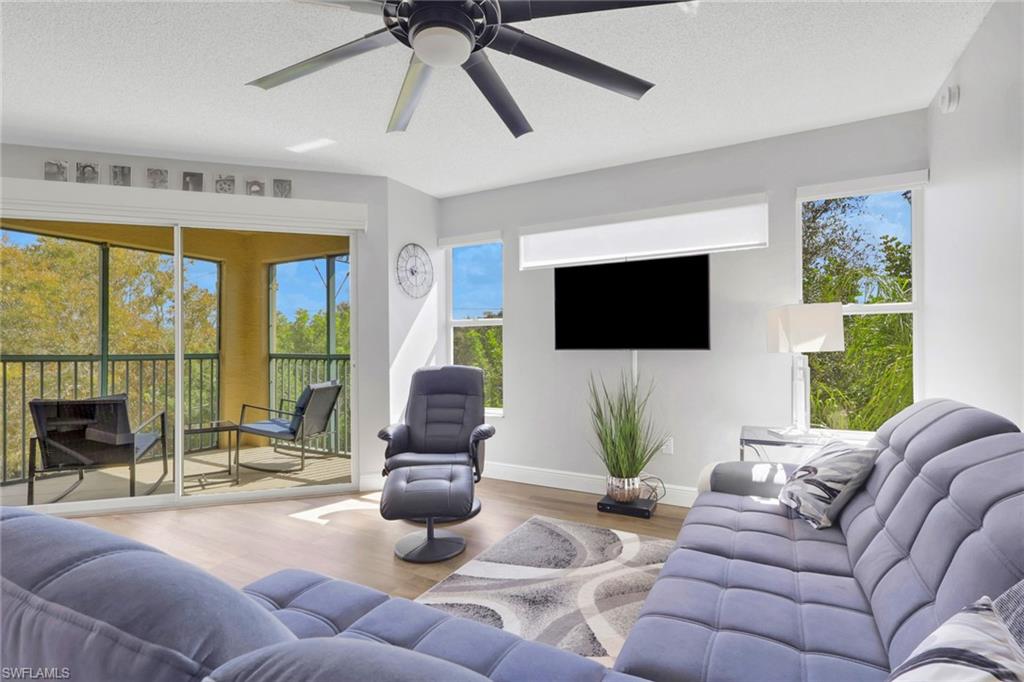 Living area featuring wood finished floors, a ceiling fan, and a textured ceiling