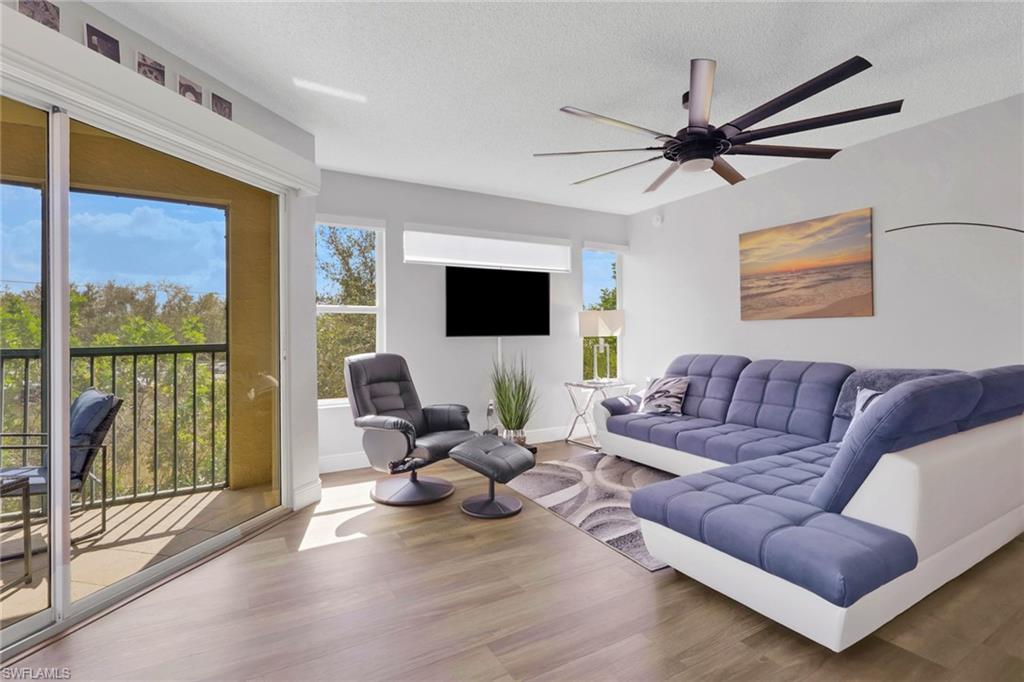 Living room featuring wood finished floors, a ceiling fan, and a textured ceiling