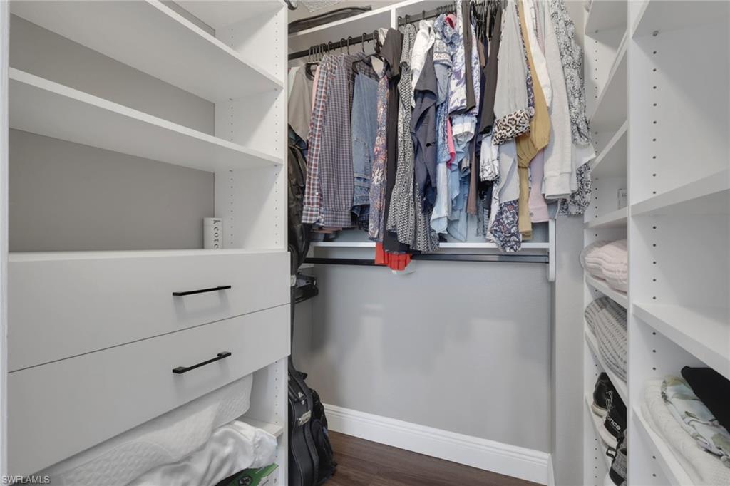 Walk in closet featuring dark wood-type flooring