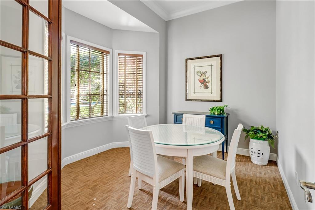 Dining area with parquet flooring and ornamental molding