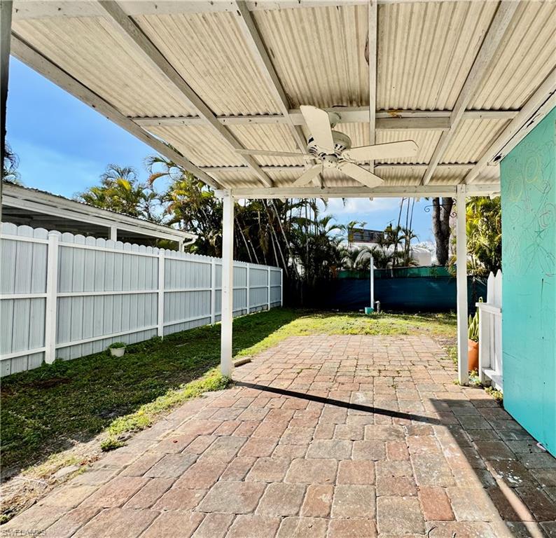 Fenced backyard featuring a ceiling fan and a patio