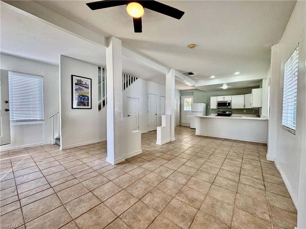 Unfurnished living room with a ceiling fan, recessed lighting, and light tile patterned floors