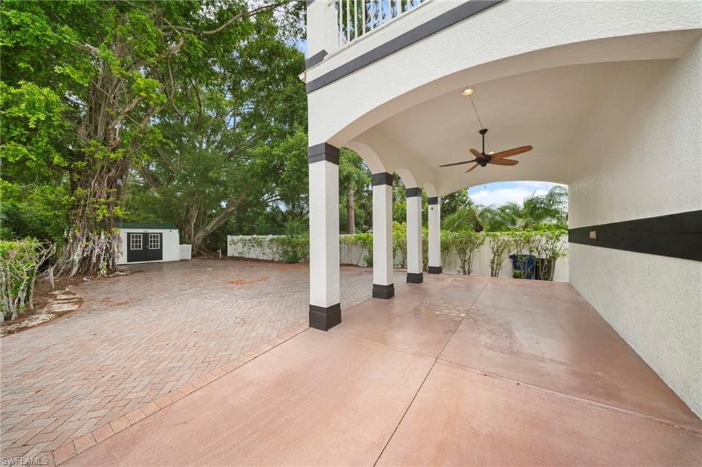 Covered entry with arched architectural details and ceiling fan