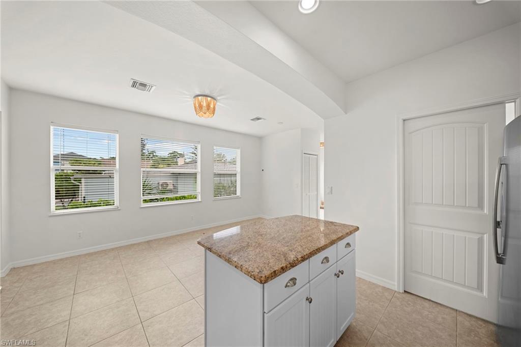Kitchen island with granite countertop and white cabinetry
