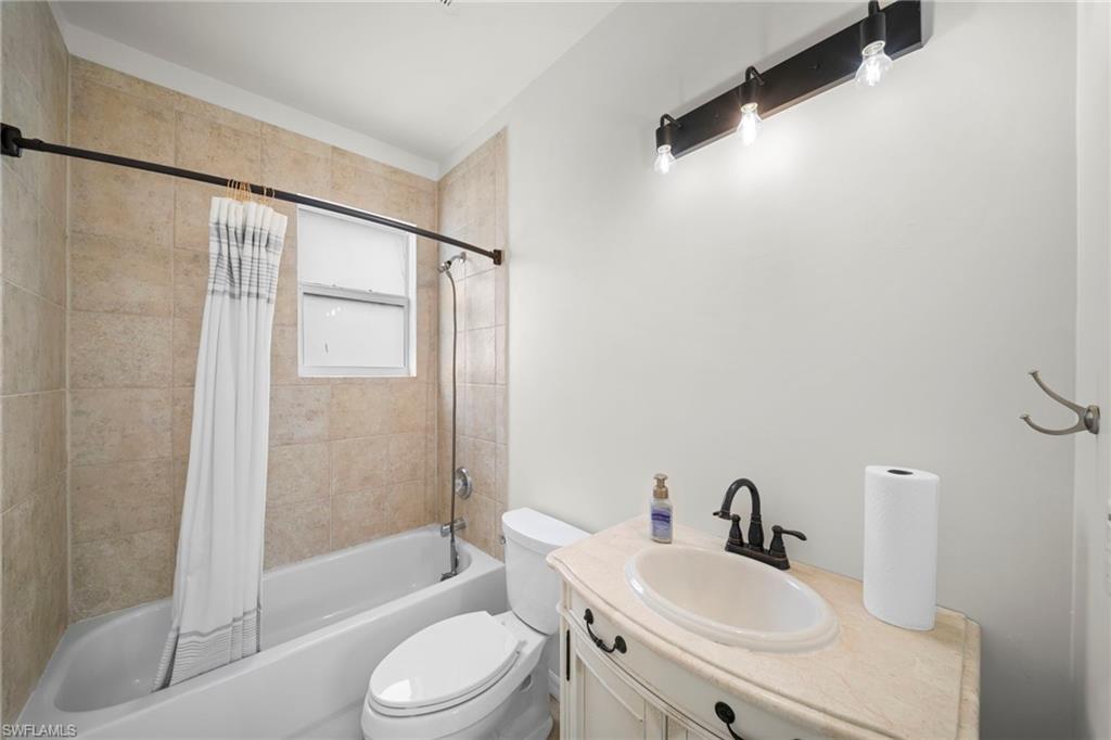 Bathroom featuring a neutral tiled shower and tub combination with a window