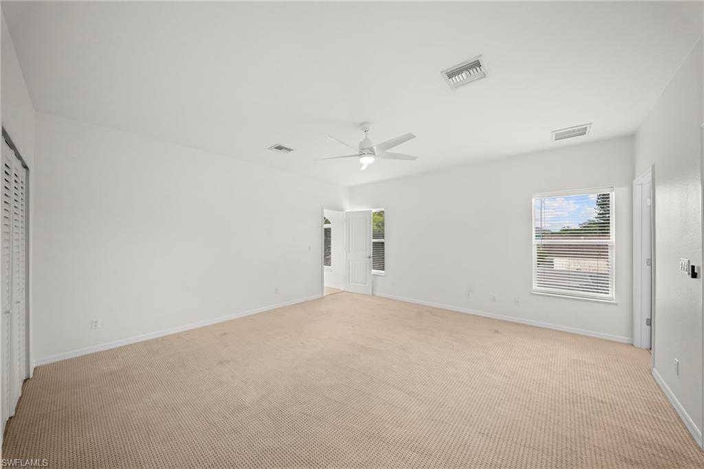 Spacious room featuring neutral carpet flooring and white walls