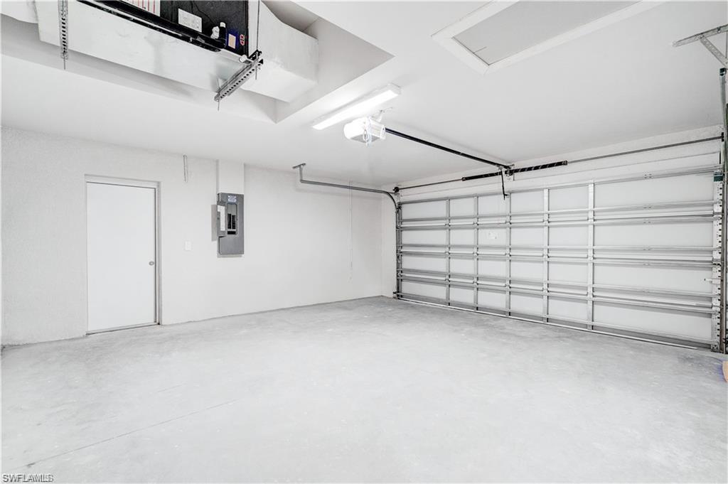 Garage with electric panel and a garage door opener