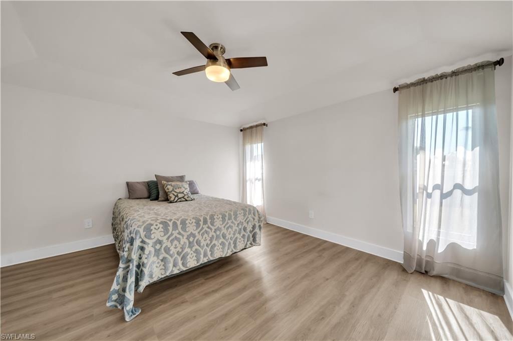 Bedroom with light wood-style floors and a ceiling fan
