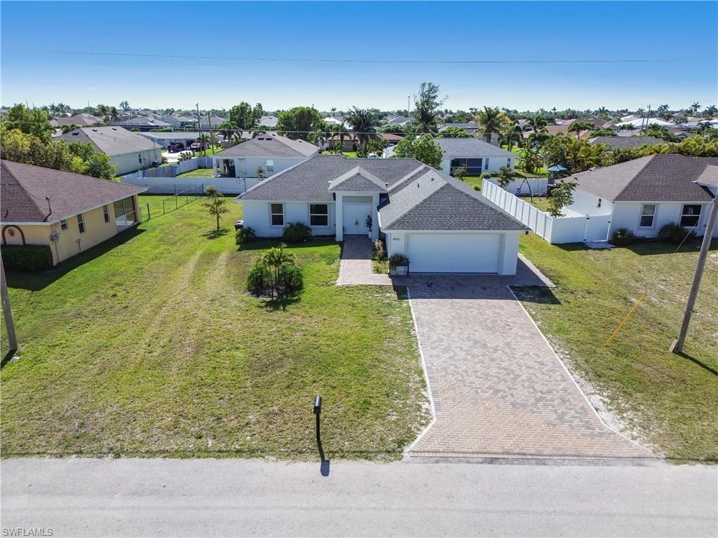 Ranch-style home featuring a residential view, decorative driveway, and a garage