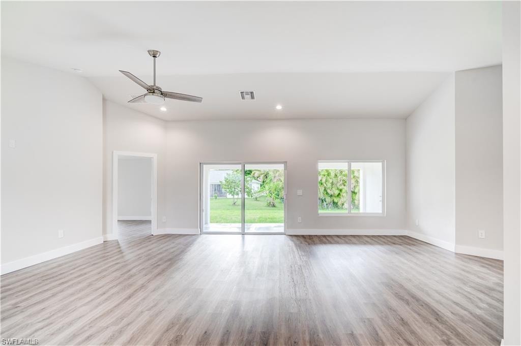 Empty room featuring a ceiling fan, light wood-style flooring, recessed lighting, and vaulted ceiling