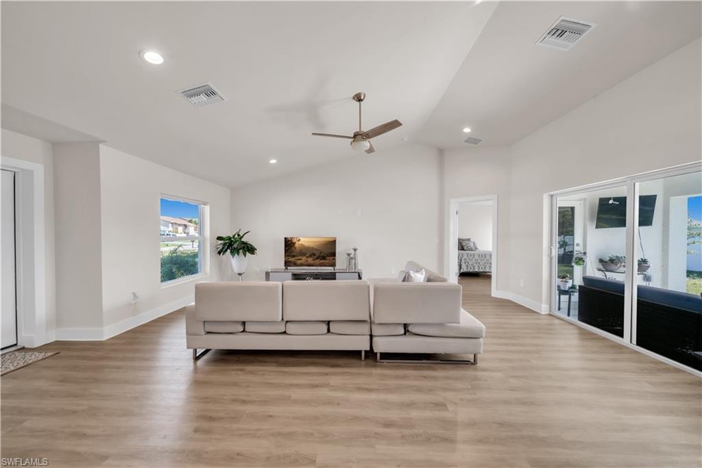 Living area featuring ceiling fan, light wood finished floors, vaulted ceiling, and recessed lighting