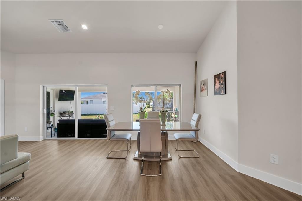 Dining room with light wood-style flooring and recessed lighting