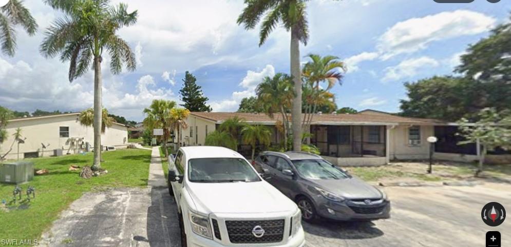 View of front of property with a front yard, a residential view, and uncovered parking