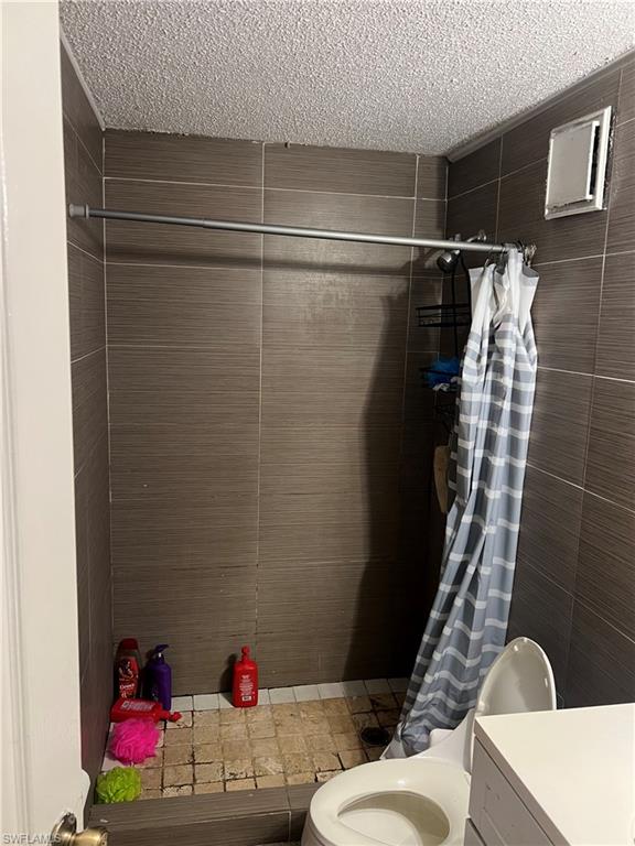 Bathroom featuring a shower stall, vanity, and a textured ceiling