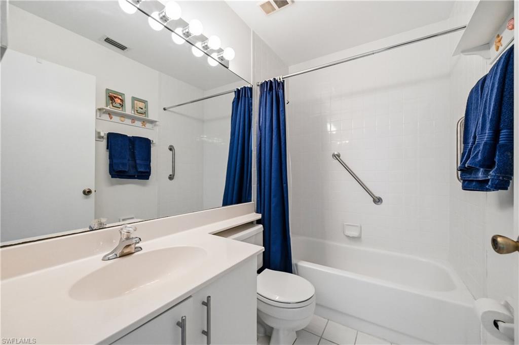 Full bath with vanity, shower / tub combo, and light tile patterned flooring