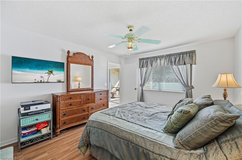 Bedroom featuring wood finished floors, ceiling fan, and a textured ceiling