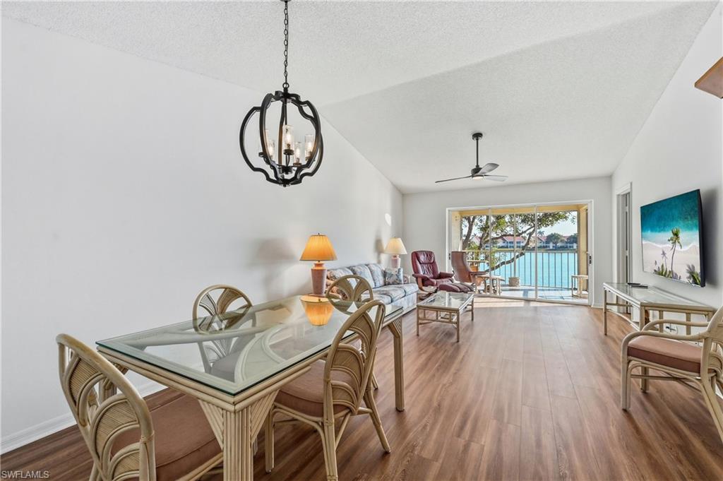Dining room with wood finished floors, ceiling fan, and suspended lighting
