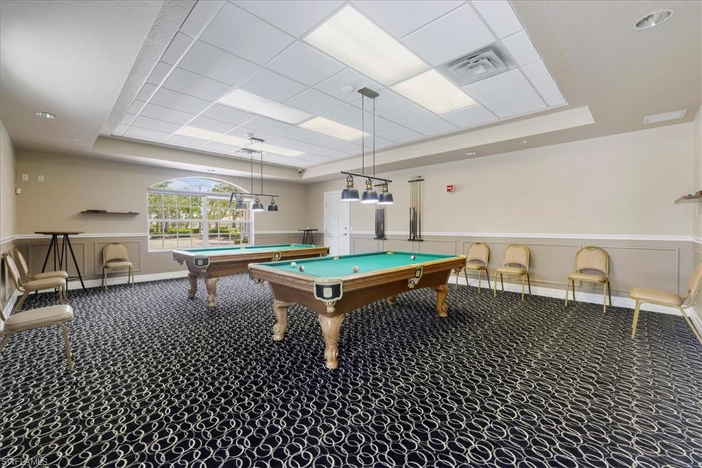 Rec room with a raised ceiling, billiards, wainscoting, and a decorative wall