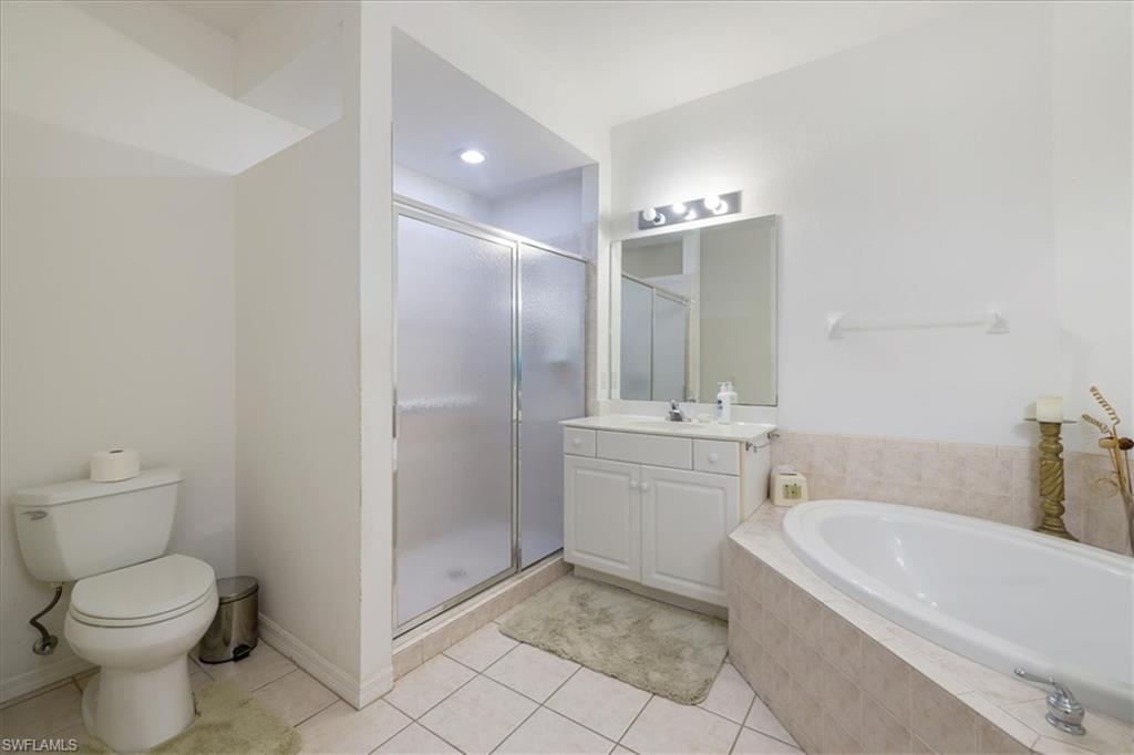 Bathroom with vanity, a stall shower, a bath, and light tile patterned floors