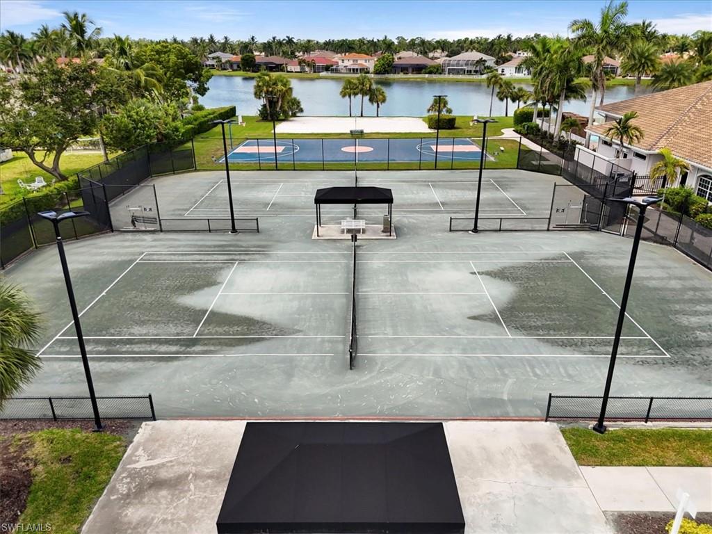View of tennis court featuring a water view and a residential view