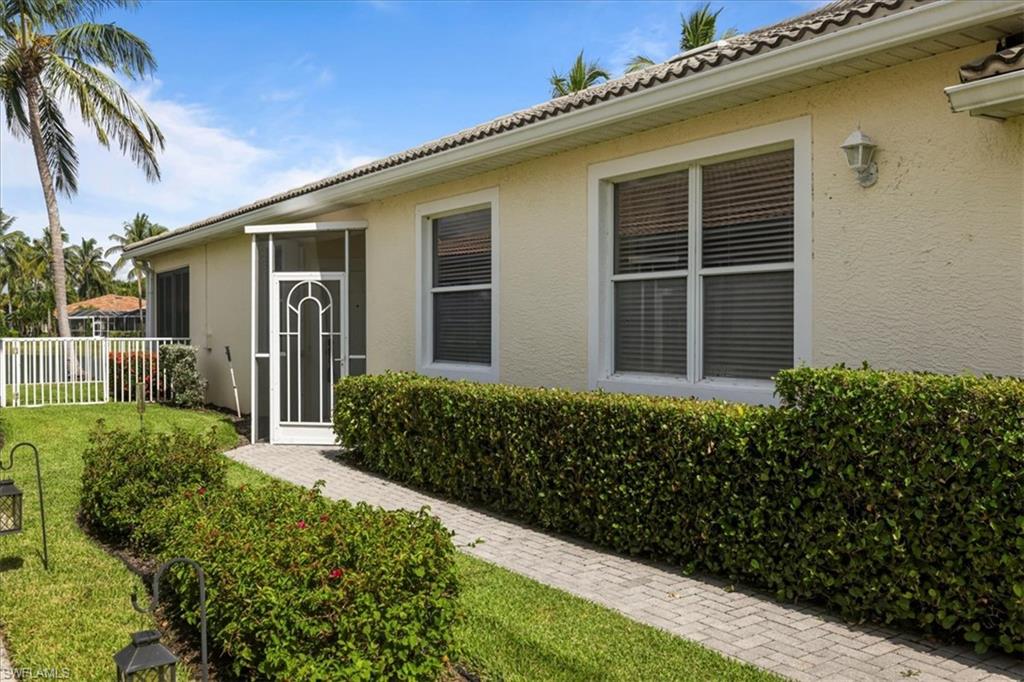 Doorway to property with stucco siding and a tile roof