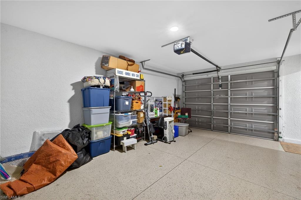Garage with a textured wall and a garage door opener