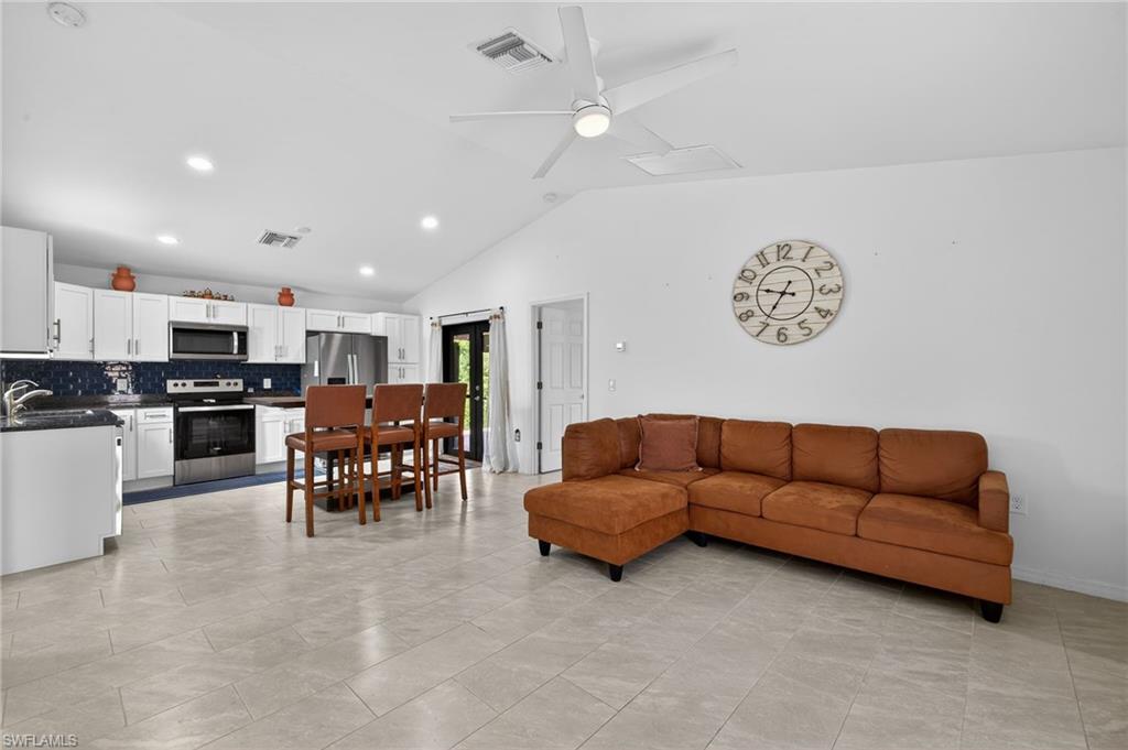 Living room featuring ceiling fan, vaulted ceiling, and recessed lighting