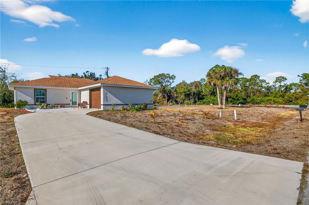 Single story home featuring stucco siding, driveway, and a garage