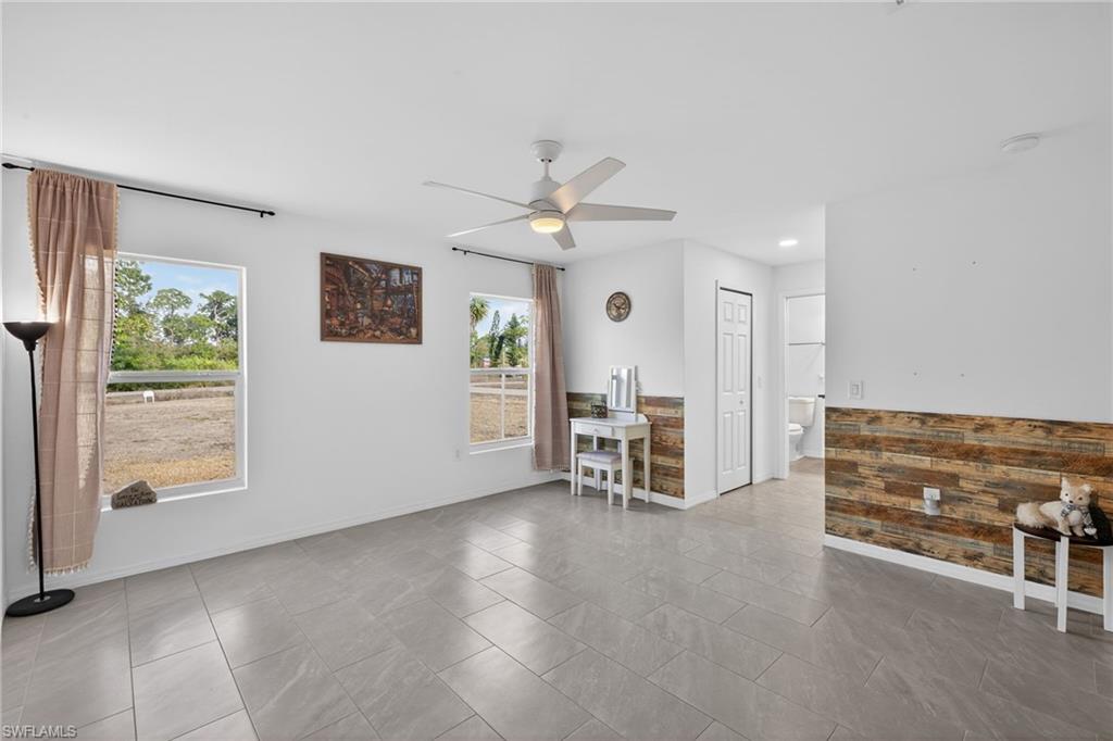 Primary Bedroom featuring ceiling fan and baseboards