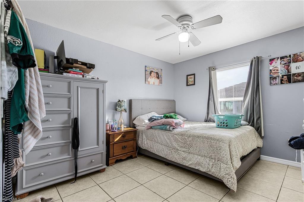 Bedroom with ceiling fan and light tile patterned floors