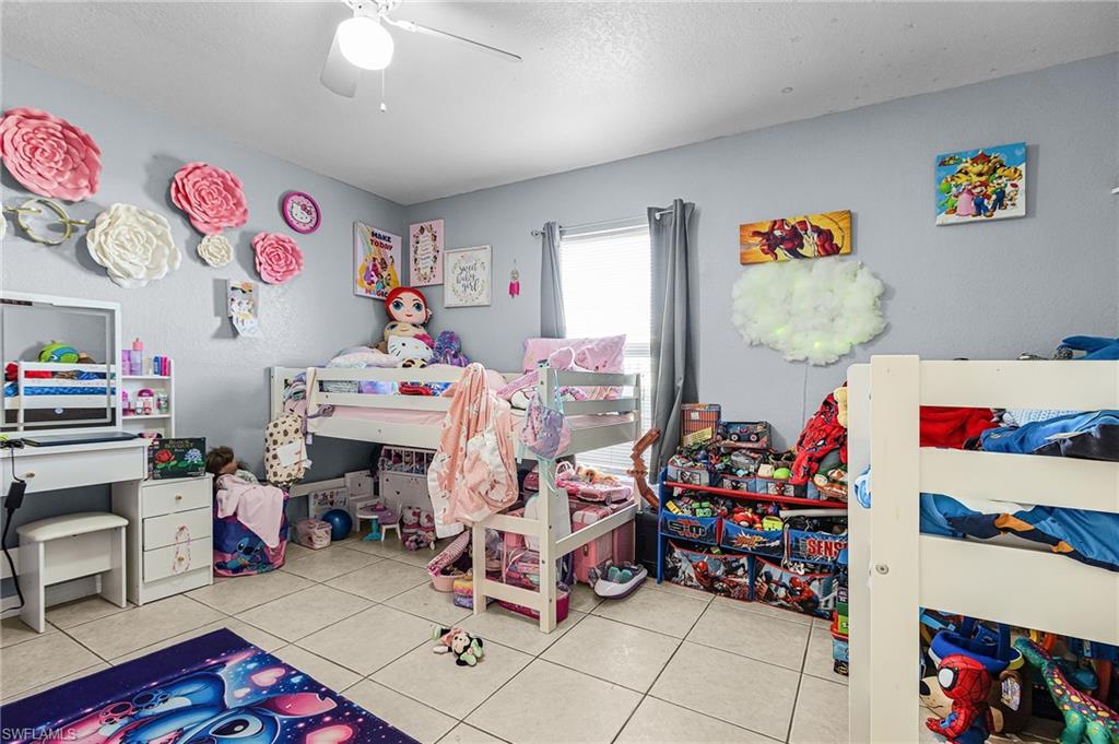 Bedroom with light tile patterned floors and a ceiling fan