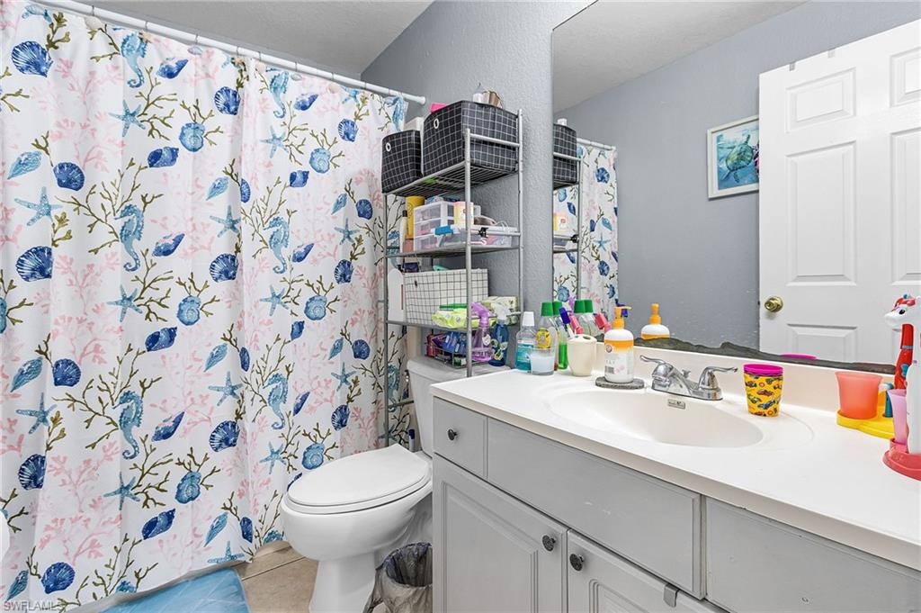 Bathroom featuring vanity, a shower with curtain, and light tile patterned floors