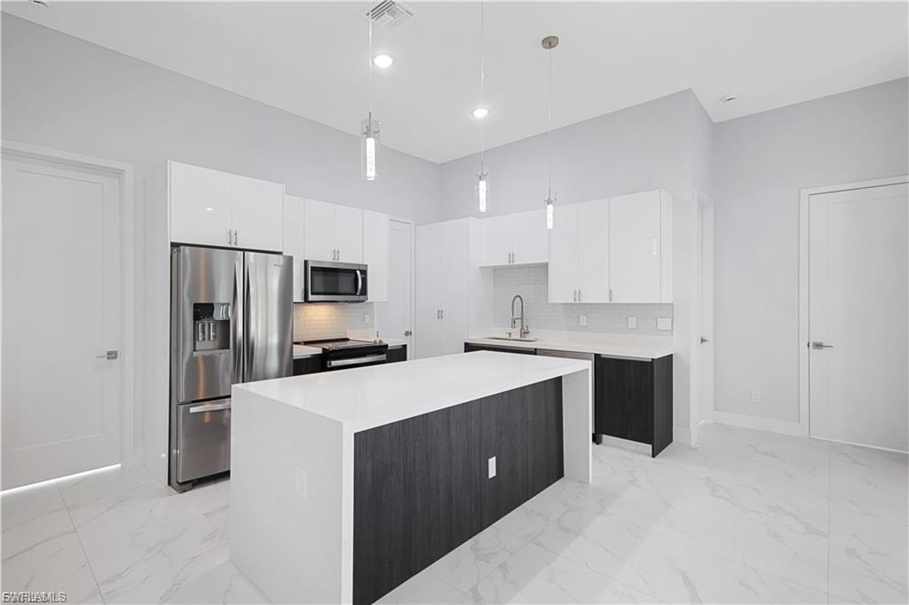 Kitchen with quartz countertops and under island shiplap decor in finished home