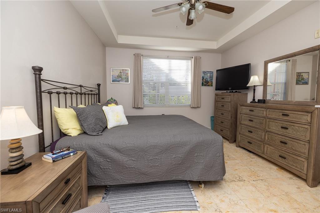 Bedroom featuring a tray ceiling and a ceiling fan