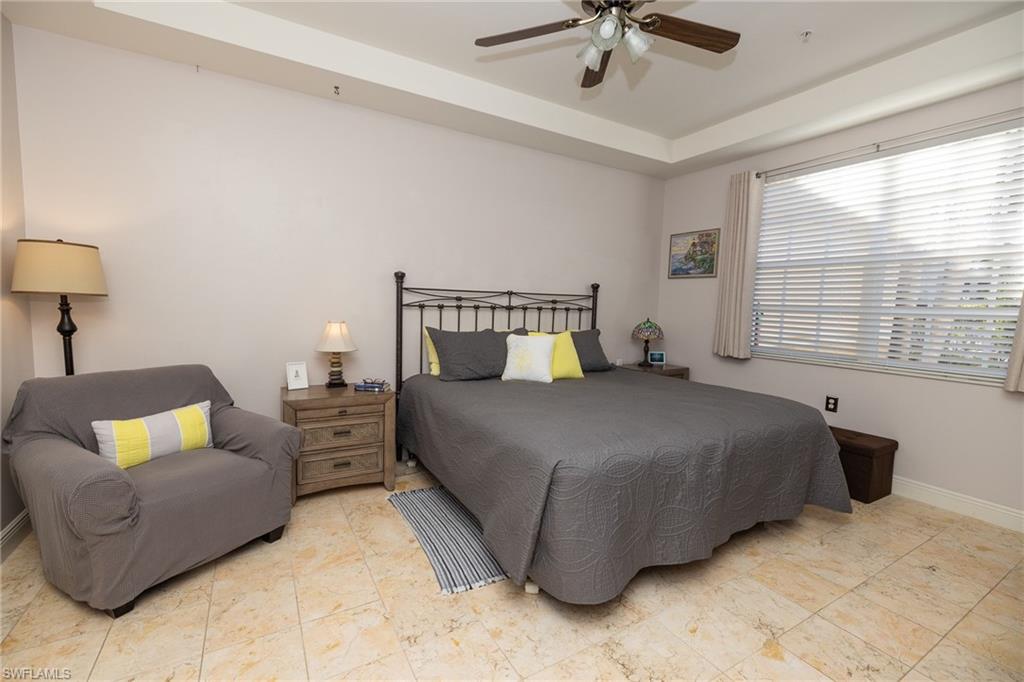 Bedroom with ceiling fan and a raised ceiling
