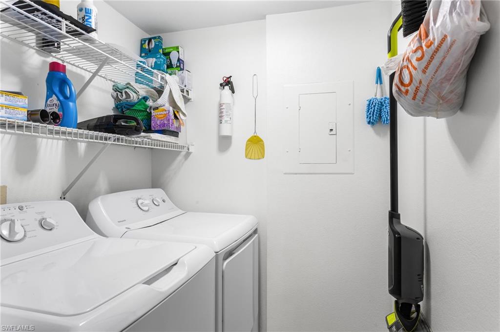 Laundry area featuring electric panel and separate washer and dryer